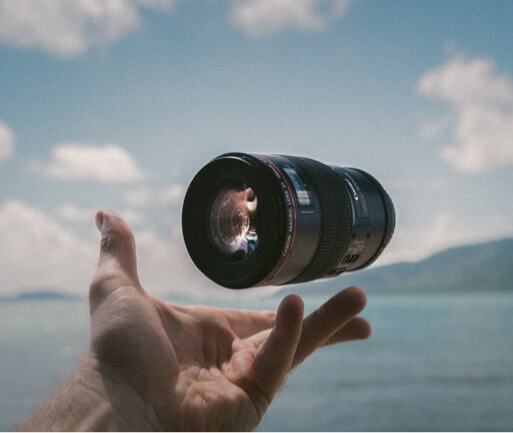 A camera lense floating in a persons hand